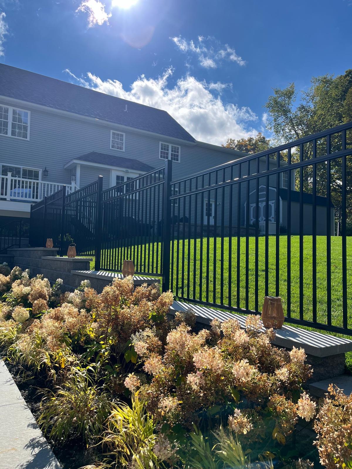 Ornamental aluminum fence running along a colonial home installed by New Horizon Fence